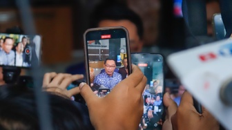 Mantan Gubernur Jawa Barat Ridwan Kamil (tengah) usai menjalani pemeriksaan di Gedung Merah Putih KPK, Jakarta, Selasa (2/12/2025). [Suara.com/Alfian Winanto]