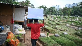 Warga mengangjut barang miliknya saat proses relokasi di area Tempat Pemakaman Umum (TPU) Menteng Pulo II, Jakarta, Selasa (2/12/2025). [ANTARA FOTO/Fauzan/foc]