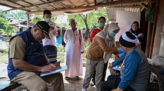 Petugas mengecek kesehatan warga saat proses relokasi di area Tempat Pemakaman Umum (TPU) Menteng Pulo II, Jakarta, Selasa (2/12/2025). [ANTARA FOTO/Fauzan/foc]