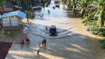 Foto udara Sejumlah kendaraan melintasi genangan banjir yang merendam jalan lintas nasional Banda Aceh-Medan di Desa Ladang Rimba, Trumon Tengah, Aceh Selatan, Aceh, Senin (1/12/2025). [ANTARA FOTO/Syifa Yulinnas/YU]