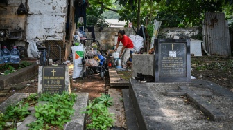 Warga mengemasi barang miliknya saat proses relokasi di area Tempat Pemakaman Umum (TPU) Menteng Pulo II, Jakarta, Selasa (2/12/2025). [ANTARA FOTO/Fauzan/foc]