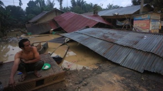 Seorang warga korban banjir berada di samping rumahnya yang hancur setelah diterjang banjir bandang di Desa Sungai Liput, Kecamatan Kejuruan, Aceh Tamiang, Aceh, Selasa (2/12/2025). [ANTARA FOTO/Syifa Yulinnas/bar]