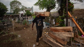 Pekerja memindahkan jasad saat proses relokasi makam di Padukuhan Kaweden, Tirtoadi, Mlati, Sleman, D.I Yogyakarta, Rabu (3/12/2025). [ANTARA FOTO/Andreas Fitri Atmoko/nym]