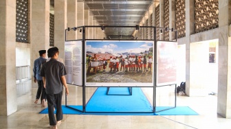 Pengunjung mengamati sejumlah karya yang ditampilkan pada pameran Haluan Merah Putih di selasar Al Fattah, Masjid Istiqlal, Jakarta, Jumat (5/12/2025). [Suara.com/Alfian Winanto]