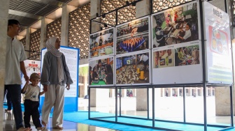 Pengunjung mengamati sejumlah karya yang ditampilkan pada pameran Haluan Merah Putih di selasar Al Fattah, Masjid Istiqlal, Jakarta, Jumat (5/12/2025). [Suara.com/Alfian Winanto]