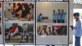 Pengunjung mengamati sejumlah karya yang ditampilkan pada pameran Haluan Merah Putih di selasar Al Fattah, Masjid Istiqlal, Jakarta, Jumat (5/12/2025). [Suara.com/Alfian Winanto]