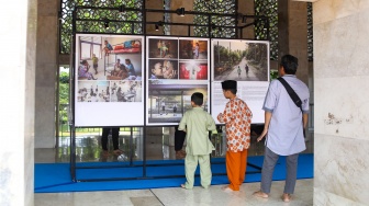 Pengunjung mengamati sejumlah karya yang ditampilkan pada pameran Haluan Merah Putih di selasar Al Fattah, Masjid Istiqlal, Jakarta, Jumat (5/12/2025). [Suara.com/Alfian Winanto]
