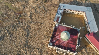 Foto udara menampilkan tumpukan kayu-kayu memenuhi area Pondok Pesantren Darul Mukhlishin pascabanjir bandang di Desa Tanjung Karang, Karang Baru, Kabupaten Aceh Tamiang, Aceh, Jumat (5/12/2025). [ANTARA FOTO/Erlangga Bregas Prakoso/app/foc]