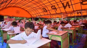 Sejumlah siswa mengikuti ujian di bawah tenda, di SDN 05 Batang Anai, Padang Pariaman, Sumatera Barat, Senin (8/12/2025). [ANTARA FOTO/Iggoy el Fitra/foc]