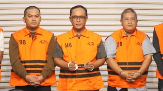 Bupati Lampung Tengah Ardito Wijaya (tengah) mengenakan rompi tahanan usai menjalani pemeriksaan di Gedung Merah Putih KPK, Jakarta, Kamis (11/12/2025). [Suara.com/Alfian Winanto]