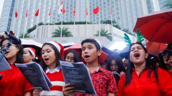 Umat Kristiani bernyanyi saat acara Christmas Carol Colossal di Bundaran HI, Jakarta, Kamis (11/12/2025). [Suara.com/Alfian Winanto]
