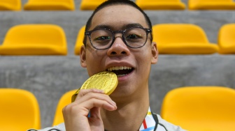 Perenang Indonesia Jason Donovan Yusuf memamerkan medali emas setelah memenangi nomor 50 meter gaya punggung putra SEA Games 2025 di SAT Swimming Pool, Bang Kapi, Bangkok, Kamis (11/12/2025). [ANTARA FOTO/Muhammad Ramdan/app/nym]