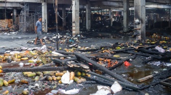 Pedagang melihat puing-puing sisa kebakaran di Pasar Induk Kramat Jati, Jakarta, Senin (15/12/2025). [Suara.com/Alfian Winanto]