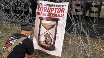 Warga Kabupaten Pati yang tergabung dalam Aliansi Masyarakat Pati Bersatu memasang poster saat melakukan unjuk rasa di depan Gedung Merah Putih KPK, Jakarta, Senin (15/12/2025). [ANTARA FOTO/Indrianto Eko Suwarso/tom]