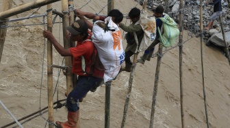 Sejumlah warga korban bencana yang terisolir melintasi Daerah Aliran Sungai (DAS) lewat jembatan tali darurat penghubung dari Desa Bergang Kecamatan Ketol, Aceh Tengah dan Desa Simpang Rahmat, Gajah Putih, Bener Meriah, Aceh, Minggu (14/12/2025). [ANTARA FOTO/Syifa Yulinnas/nz]