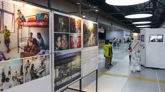 Calon penumpang melintas di dekat sejumlah karya pada pameran Haluan Merah Putih di Stasiun Tanah Abang, Jakarta, Senin (15/12/2025). [Suara.com/Alfian Winanto]