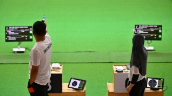 Dua petembak Indonesia Muhammad Iqbal Raia prabowo (kiri) dan Arista Perdana Putri Darmoyo (kanan) membidik sasaran dalam final nomor 10 meter Air Rifle tim campuran cabang menembak SEA Games 2025 di Photharam Shooting Range, Bangkok, Thailand, Senin (15/12/2025). [ANTARA FOTO/Nova Wahyudi/tom]
