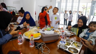 Sejumlah orang tua memberikan Makan Bergizi Gratis (MBG) kepada anak-anak dalam kegiatan Cegah Stunting (Centing) yang digelar di Jimmy Hantu Foundation, Kecamatan Tamansari, Kabupaten Bogor, Jawa Barat, Selasa (16/12/2025). [Suara.com/Alfian Winanto]