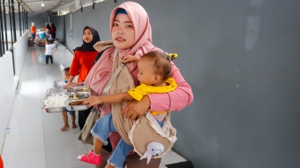 Sejumlah orang tua memberikan Makan Bergizi Gratis (MBG) kepada anak-anak dalam kegiatan Cegah Stunting (Centing) yang digelar di Jimmy Hantu Foundation, Kecamatan Tamansari, Kabupaten Bogor, Jawa Barat, Selasa (16/12/2025). [Suara.com/Alfian Winanto]