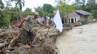 Warga memasangkan bendera putih di depan rumahnya yang rusak pasca bencana hidrometeorologi di Desa Lawet, Kecamatan Pante Ceureumen, Aceh Barat, Aceh, Rabu (17/12/2025). [ANTARA FOTO/Syifa Yulinnas/foc]