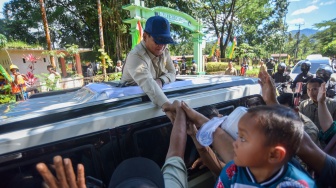 Presiden Prabowo Subianto menyapa masyarakat saat tiba di Nagari Kayu Tanam, Padang Pariaman, Sumatera Barat, Kamis (18/12/2025). [ANTARA FOTO/Iggoy el Fitra/tom]