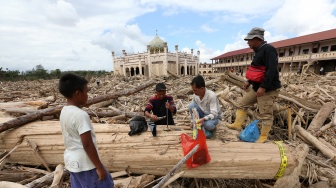 Petugas Kementerian Kehutanan dan Dinas Kehutanan Provinsi Aceh mengambil sampel kayu gelondongan yang terbawa arus luapan Sungai Tamiang, di area pasantren Islam Terpadu Darul Mukhlishin, Desa Tanjung Karang, Aceh Tamiang, Aceh, Jumat (19/12/2025). [ANTARA FOTO/Irwansyah Putra/nym]