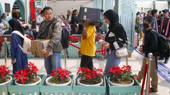 Penumpang menunggu kedatangan kereta api di Stasiun Pasar Senen, Jakarta Pusat, Senin (22/12/2025). [Suara.com/Alfian Winanto]