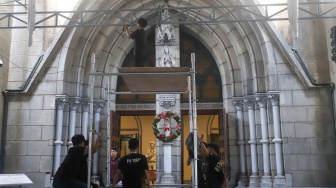 Petugas memasang dekorasi di Gereja Katedral, Jakarta, Selasa (23/12/2025). [Suara.com/Alfian Winanto]