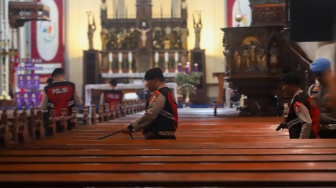 Petugas memeriksa keamanan di Gereja Katedral, Jakarta, Selasa (23/12/2025). [Suara.com/Alfian Winanto]
