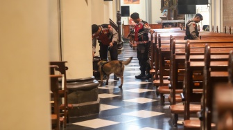 Petugas memeriksa keamanan di Gereja Katedral, Jakarta, Selasa (23/12/2025). [Suara.com/Alfian Winanto]
