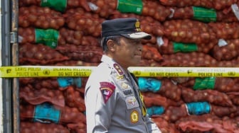 Kapolda Jawa Timur Irjen Pol Nanang Avianto berjalan di dekat barang bukti saat ungkap kasus pengiriman bawang bombay secara ilegal di salah satu lapangan penumpukan kontainer di kawasan Pelabuhan Tanjung Perak, Surabaya, Jawa Timur, Selasa (23/12/2025). [ANTARA FOTO/Didik Suhartono/bar]