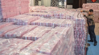 Petugas menata tumpukan uang hasil penagihan denda administratif kehutanan dan penyelamatan keuangan negara dari hasil tindak pidana korupsi di kompleks Kejaksaan Agung, Jakarta, Rabu (24/12/2025). [ANTARA FOTO/Aditya Pradana Putra/sgd]