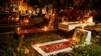 Warga keturunan Portugis saat ziarah makam anggota keluarga mereka pada malam Natal di kompleks Gereja Protestan Indonesia Barat (GPIB) Tugu, Semper Barat, Cilincing, Jakarta, Rabu (24/12/2025).  [Suara.com/Alfian Winanto]