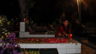 Warga keturunan Portugis saat ziarah makam anggota keluarga mereka pada malam Natal di kompleks Gereja Protestan Indonesia Barat (GPIB) Tugu, Semper Barat, Cilincing, Jakarta, Rabu (24/12/2025).  [Suara.com/Alfian Winanto]