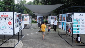 Wisatawan melihat karya foto pada pameran Haluan Merah Putih di Taman Margasatwa Ragunan (TMR) di Jakarta, Kamis (25/12/2025). [Suara.com/Alfian Winanto]
