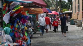 Pengunjung berwisata di Pantai Lagoon, Taman Impian Jaya Ancol, Jakarta, Jumat (26/12/2025). [Suara.com/Alfian Winanto]