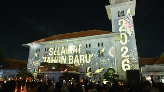 Warga menyaksikan pertunjukan video mapping saat malam pergantian tahun baru 2026 di Balai Kota Madiun, Jawa Timur, Kamis (1/1/2026). [ANTARA FOTO/Fikri Yusuf/wpa.]