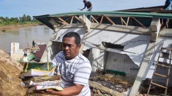Warga menyelamatkan Al Quran dari bangunan Taman Pendidikan Al-Quran di kawasan Masjid Jamaatul Yaqin Banda Cino, Talao Mundam, Nagari Katapiang, Padang Pariaman, Sumatera Barat, Minggu (4/1/2026). [ANTARA FOTO/Iggoy el Fitra/nym]