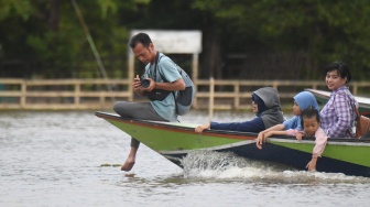 Sejumlah pengunjung menaiki perahu motor untuk mengamati Pesut Mahakam (Orcaella brevirostris) di Desa Wisata Pela di Kutai Kartanegara, Kalimantan Timur, Minggu (4/1/2026). [ANTARA FOTO/M Risyal Hidayat/YU]