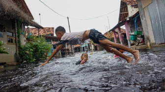 Sejumlah anak bermain air di jalan perkampungan yang tergenang banjir di Pabean, Kota Pekalongan, Jawa Tengah, Rabu (7/1/2026). [ANTARA FOTO/Harviyan Perdana Putra/foc]