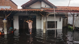 Warga berjalan melewati depan rumahnya yang tergenang banjir di Pabean, Kota Pekalongan, Jawa Tengah, Rabu (7/1/2026). [ANTARA FOTO/Harviyan Perdana Putra/foc]