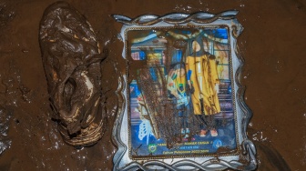 Sebuah foto dan sepatu tergeletak di dalam rumah warga yang dipenuhi lumpur pascabanjir di Desa Tongute Ternate asal Kabupaten Halmahera Barat, Maluku Utara, Kamis (8/1/2026). [ANTARA FOTO/Andri Saputra/tom]