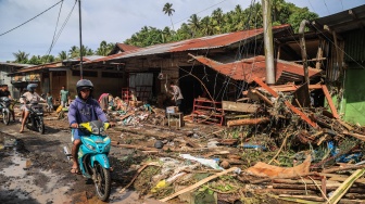 Pengendara sepeda motor melintas di depan rumah warga yang rusak pascabanjir di Desa Tongute Ternate asal Kabupaten Halmahera Barat, Maluku Utara, Kamis (8/1/2026). [ANTARA FOTO/Andri Saputra/tom]