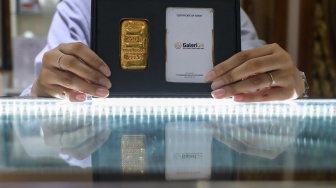 Pramuniaga menunjukkan emas batangan di sebuah gerai Galeri 24, Jakarta, Jumat (9/1/2026). [Suara.com/Alfian Winanto]