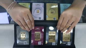 Pramuniaga menunjukkan emas batangan di sebuah gerai Galeri 24, Jakarta, Jumat (9/1/2026). [Suara.com/Alfian Winanto]