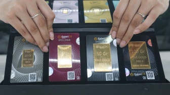 Pramuniaga menunjukkan emas batangan di sebuah gerai Galeri 24, Jakarta, Jumat (9/1/2026). [Suara.com/Alfian Winanto]