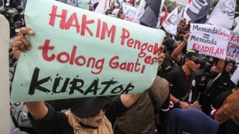 Mantan buruh dan karyawan Sritex membentangkan poster saat melakukan aksi unjuk rasa di depan kantor Pengadilan Negeri Semarang, Jawa Tengah, Senin (12/1/2026). [ANTARA FOTO/Makna Zaezar/nz]