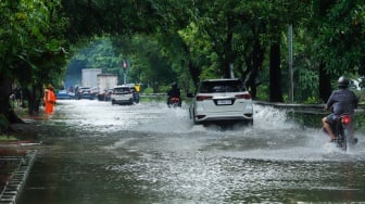 Pengendara menorobos banjir yang menggenang di Jalan Danau Sunter Raya, Jakarta, Senin (12/1/2026). [Suara.com/Alfian Winanto]