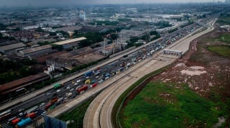 Foto udara kendaraan melintas di samping akses tol langsung KM 25 Jakarta-Merak di Curug, Kabupaten Tangerang, Banten, Selasa (13/1/2026). [ANTARA FOTO/Putra M. Akbar/tom]
