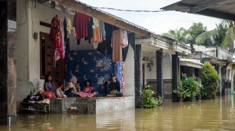 Warga melintasi jalan yang tergenang banjir menggunakan perahu rakit di Perumahan Taman Cikande, Jayanti, Kabupaten Tangerang, Banten, Rabu (14/1/2026). [ANTARA FOTO/Putra M. Akbar/foc]